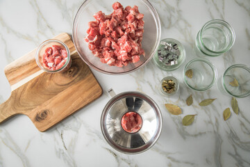 Schulter Fleisch roh und Lorbeer mit Trichter in Einkochglas zum selbstgemacht Einkochen für...