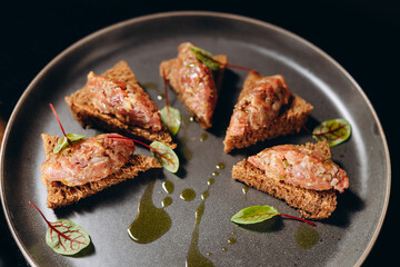 Veal tartare on black bread dressed with olive oil.
