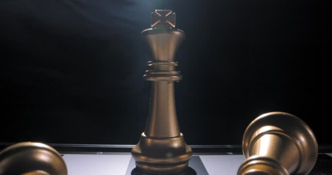 Gold king on chess board last survivor, dramatic twirling smoke behind