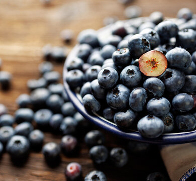 Close-up view of fresh blueberries in the bowl, focus on the cut blueberries in the center