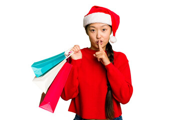 Young asian woman shopping a christmas presents isolated Young asian woman shopping a christmas presents isolated keeping a secret or asking for silence.