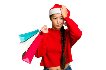 Young asian woman shopping a christmas presents isolated Young asian woman shopping a christmas presents isolated being shocked, she has remembered important meeting.