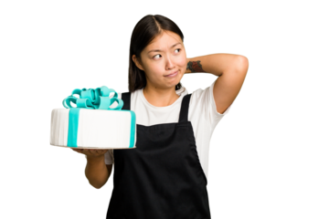 Young asian bakery holding a birthday cake isolated touching back of head, thinking and making a choice.