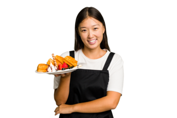 Young asian waitress woman holding waffles isolated laughing and having fun.
