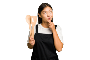 Young asian cook woman isolated looking sideways with doubtful and skeptical expression.