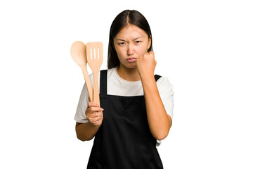 Young asian cook woman isolated showing fist to camera, aggressive facial expression.