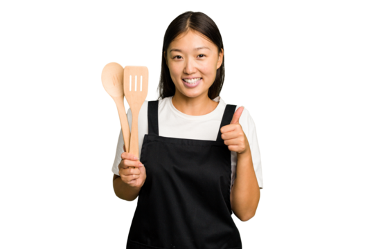 Young asian cook woman isolated smiling and raising thumb up - Powered by Adobe