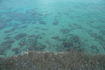 View from the cliff of a flat and crystal clear sea