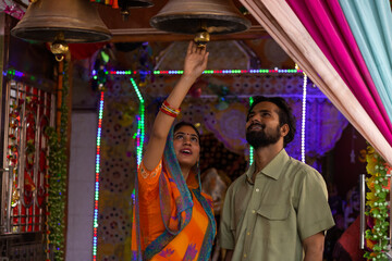 Portrait of young couple praying together at temple