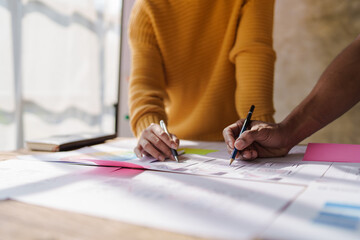 A UX design team is a confluence of user research, UX, UI design with layout paper on desk.