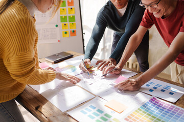 A UX design team is a confluence of user research, UX, UI design with layout paper on desk.