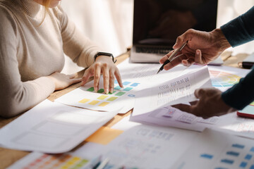 A UX design team is a confluence of user research, UX, UI design with layout paper on desk.
