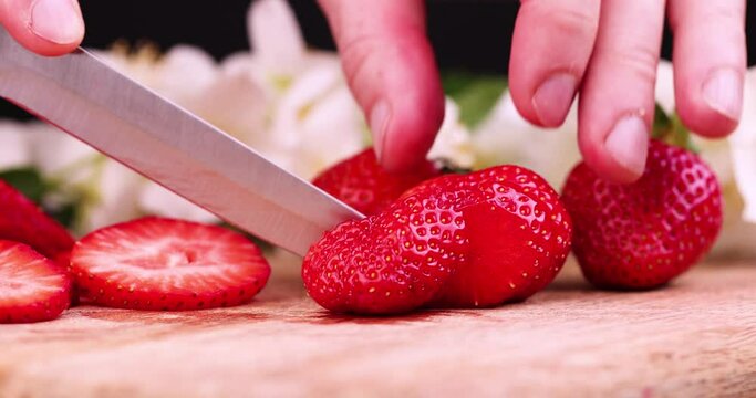 Cut into pieces ripe red strawberries, red strawberries are divided into slices for dessert