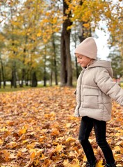 girl running in the yellow leaves in autumn park. 