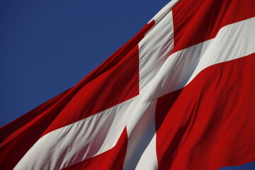 Close up of the flag of Denmark waving in the air against blue sky