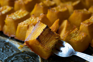 Baked pumpkin pieces on a baking sheet