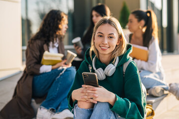 portrait of young adult female student outdoor in campus. friends in blurred background