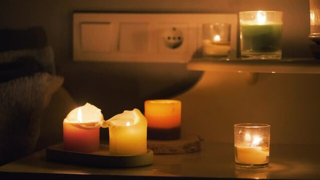Candles in a dark room. Burning candles on the table and sockets on the background. No electricity in the house. Blackout in the city. Power outage, energy crisis concept