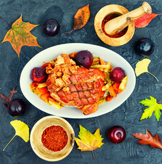 Pork shoulder roasted with vegetables and plums.