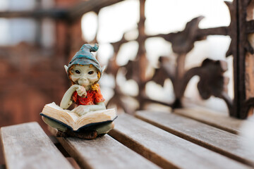 A figurine of a fairy-tale character reading a book