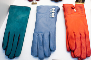 Women's leather gloves of different colors in a shop window