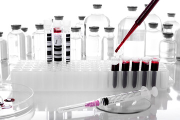 Pipette drop blood sample onto PCR tube or red liquid on PCR plate in the laboratory background-...