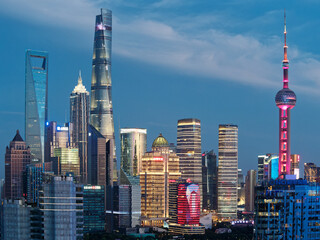 Moderne Wolkenkratzer, Shanghai Tower, Jin Mao Tower, Oriental Pearl TV Tower und Shanghai World Financial Center, Wahrzeichen in Lujiazui mit blauem Himmelshintergrund in der Abenddämmerung