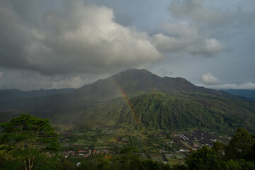 Obraz na płótnie Canvas Landscape view of volcano mount Batur with a rainbow located in Kintamani area in Bali, Indonesia