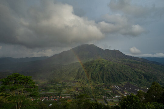 Landscape view of volcano mount Batur with a rainbow located in Kintamani area in Bali, Indonesia