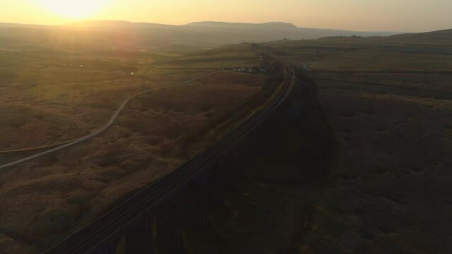 Aerial Drone Shot Over Ribblehead Viaduct Train Bridge at Stunning Sunrise in Summer in Yorkshire Dales England UK with Hills in Background