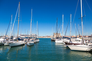 Fototapeta na wymiar Marina bay with yachts, vessels, sailboats and other ships in Livorno, Italy. Sunny day with blue sky and sea water 