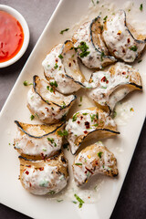 Tandoori momo, veg or non veg in red and cream sauce, served with sauce.  Nepal and Tibet recipe