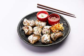 Tandoori momo, veg or non veg in red and cream sauce, served with sauce.  Nepal and Tibet recipe