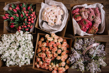 Many beautiful flower mono bouquets of fresh roses, ranunculus, lilac, matthiola, tulips, wrapped...