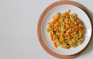 Pilaf with rice, chickpeas and spices on white background with copy space