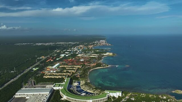 Aerial view over hotels on the coastline of Xpu-Ha, Mayan Riviera, Mexico - pull back, drone shot