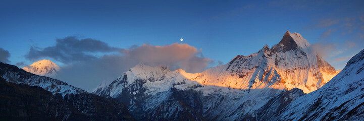 Wide panorama of the Himalaya mountains with Mt. Machapuchare and Annapurna III at sunset, view from Annapurna base camp.