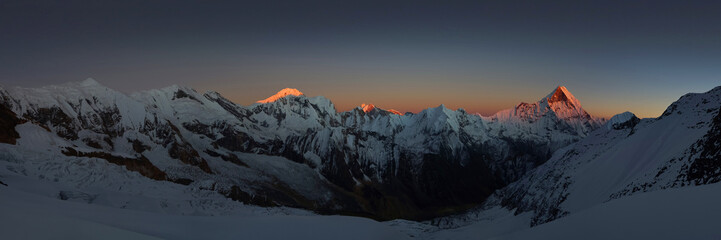 Wide panorama of the Himalaya mountains at sunset. Mountain range with Machapucchare (Fishtail) and Annapurna III peaks.