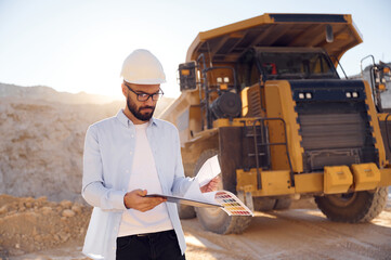 Fototapeta premium Smart man in glasses and in uniform is working in the quarry at daytime