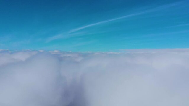Fly from bottom to top in the sky among clouds aerial drone view. Flight in blue cloudscape