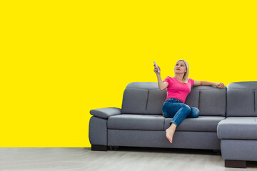 Front view full length joyful young mixed race woman relaxing on cozy couch in living room, holding...