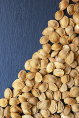 Dry apricot stones on black background. Copy space