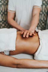 Beautiful young woman receiving professional body massage treatment with aromatherapy essential oil.