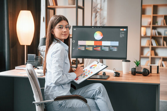 Young female retoucher working with computer and graphic tablet