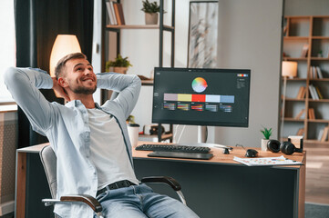 Designer is sitting by the computer and using graphics tablet with stylus