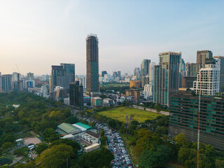 Obraz premium Aerial view modern office buildings and condominium park in Bangkok city downtown with sunset sky and clouds