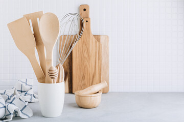 Kitchen utensils. Kitchen wooden tools and kitchenware. White modern kitchen interior background.