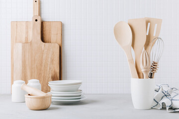 Kitchen utensils. Kitchen wooden tools and kitchenware. White modern kitchen interior background.