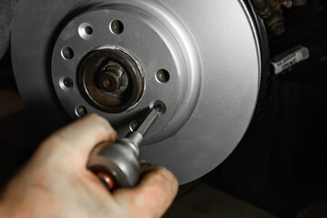 Car mechanic hands installing new car brake discs.