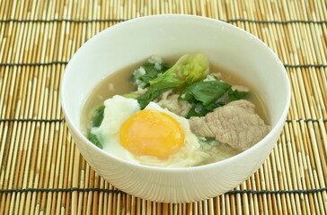 boiled rice with slice fermenting  pork and cabbage topping egg yolk on bowl 